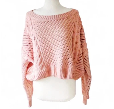 Suéter tejido con cable fuera del hombro con cuello de barco recortado Urban Outfitters en rosa Foto 1 de 4