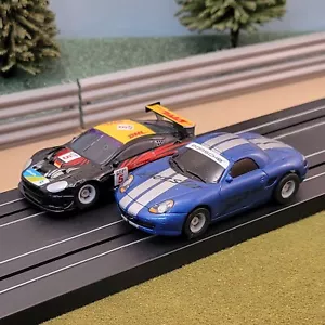 Par de coches Micro Scalextric 1:64 - Aston Martin DBR9 DHL y Porsche Boxster azul - Imagen 1 de 1