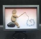 PEBBLE ART CHARACTER PERCHED ON ROCK FISHING