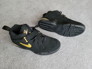 black nike shoes with gold tick