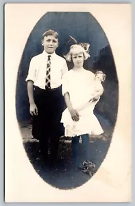 Postcard RPPC c1910s Photograph of two Kids Brother Sister Holding Doll - Picture 1 of 2