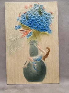Cartolina d'epoca Auguri Fiori Blu in rilievo in vaso Ragazza su vaso 1909 - Foto 1 di 2