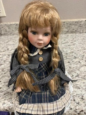 Muñeca de porcelana vintage trenzas rubias, vestido a cuadros azul/verde botas negras sentadas Foto 1 de 4