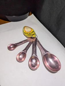 NWT VINTAGE COPPER PINK COLORED ALUMINUM MEASURING SPOONS SET OF 4 BY FAIRGROVE - Picture 1 of 5