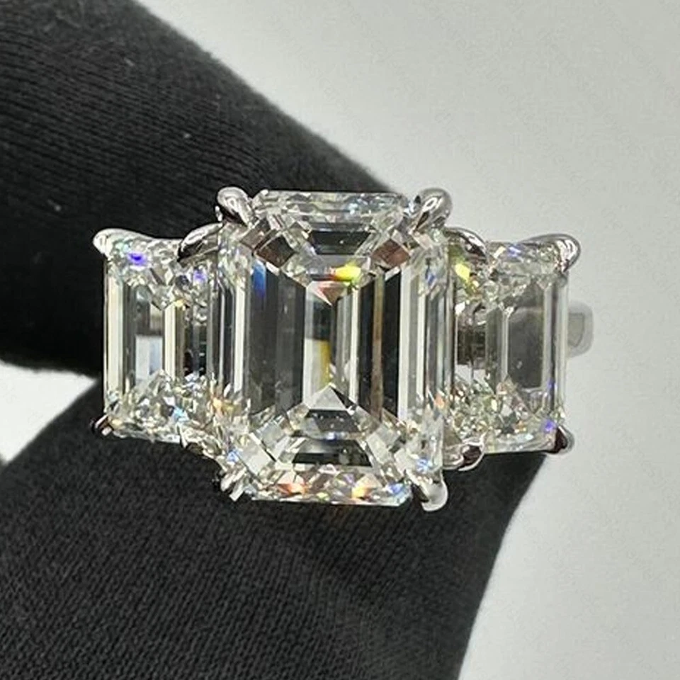 Anillo de compromiso de tres piedras de moissanita talla esmeralda de 7,49 quilates enchapado en oro blanco de 14 quilates Foto 1 de 4