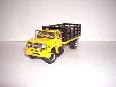 DCP FIRST GEAR 1/64 YELLOW CAB BLACK STAKE SIDE GMC 6500 SINGLE AXLE TRUCK  - Image 1 of 4