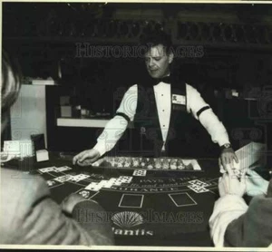 1985 Press Photo A blackjack dealer and players at Atlantis, Atlantic City - Picture 1 of 2