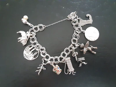 PULSERA DE PLATA REVUELTA VINTAGE CON 10 DIJES ORIENTADOS A VIAJES DE LEY Foto 1 de 4