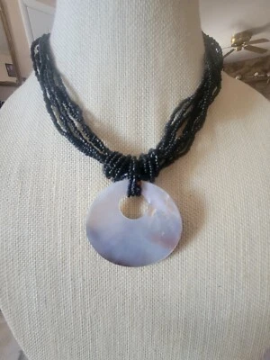 Collar de cuentas de semillas de varias hebras negro con medallón redondo de concha de abulón Foto 1 de 4