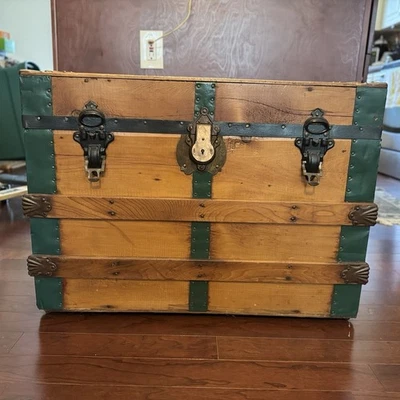 Baúl de viaje de madera vintage con adornos de metal verde y listones de madera  Foto 1 de 4