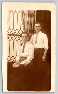 Portrait Two Men in Shirts & Ties, One Seated, Before Diamond Pane Window RPPC - Picture 1 of 2