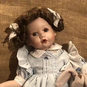 Trecce e riccioli su una bellissima bambola con pinafore sopra vestito blu vintage - Foto 1 di 7