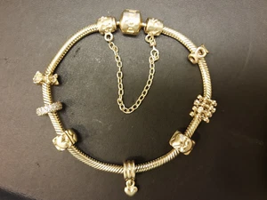 PANDORA Armband Gold mit 5 Charms, 2 Clips und 1 Sicherheitskette 585/- - Bild 1 von 11