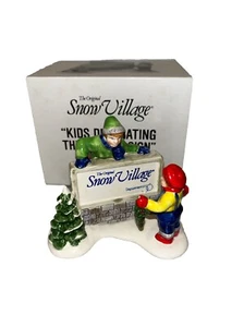 Department 56 Snow Village - "Letrero de niños decorando el pueblo" #5134-9 - Imagen 1 de 4