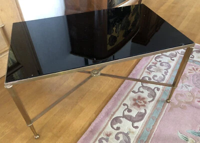 Table basse en métal doré, pieds reliés par entretoise dans le goût de BAGUES - Photo 1/4