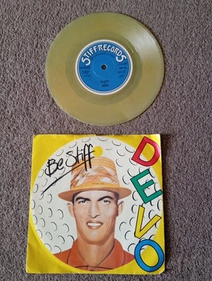 DEVO -  BE STIFF  7'' TRANSPARENT  YELLOW MILKY VINYL SINGLE IN PICTURE SLEEVE  - Image 1 of 4