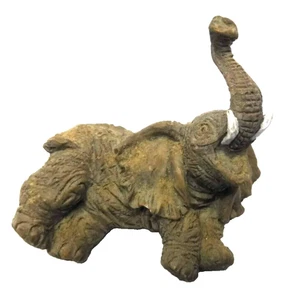Estatuilla pequeña vintage bebé elefante marrón baúl acostado colmillos blancos - Imagen 1 de 7