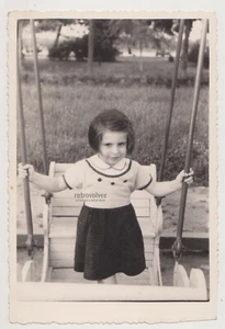 Süßes junges Mädchen auf einer Schaukel, das die Freude eines Aufwärtsgleitens einfängt Schnappschussfoto - Bild 1 von 7