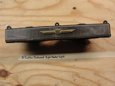 84 Cadillac Fleetwood RIGHT PARK MARKER TURN SIGNAL LIGHT LENS GOLD CREST EMBLEM - Image 1 of 4