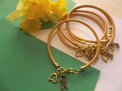 CINCO (5) PULSERAS DE CONCIENTIZACIÓN SOBRE EL CÁNCER INFANTIL CON ENCANTO DE CINTA DE ESPERANZA DORADA Foto 1 de 3