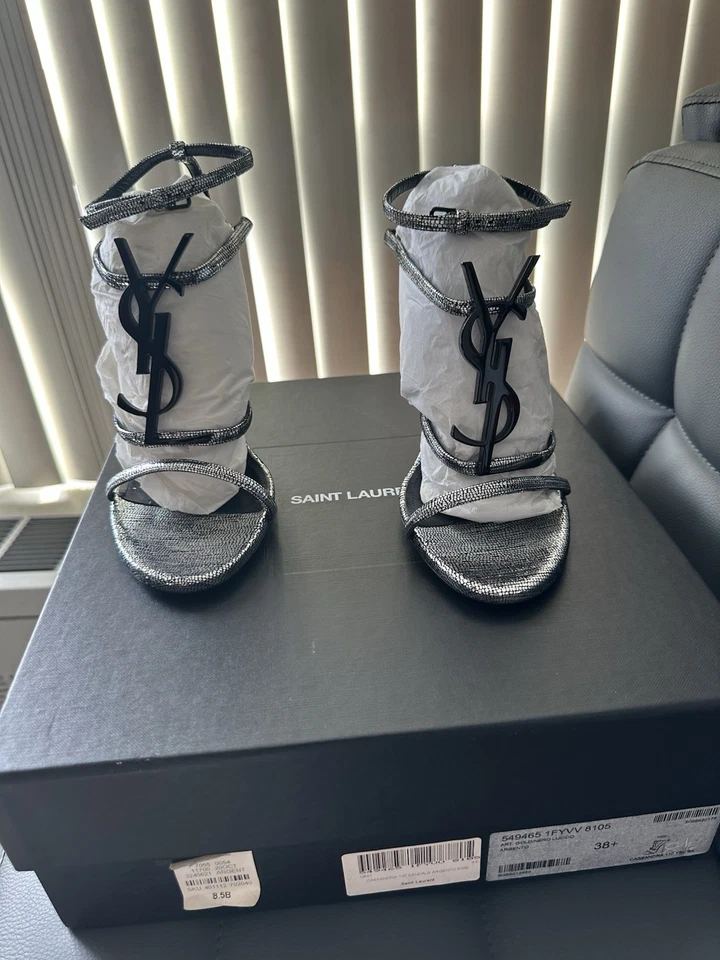 Cartera plegable de cuero negra Saint Laurent Cassandra plateada con logotipo YSL Foto 1 de 4