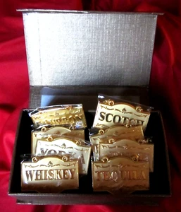 INCREÍBLE JUEGO DE 8 ETIQUETAS DE LICOR COLOR DORADO EN CAJA CON CADENAS, TOTALMENTE NUEVAS - Imagen 1 de 8