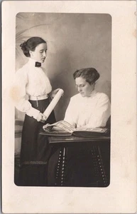 c1910s Studio RPPC Real Photo Postcard Two Pretty Young Ladies / Photo Album - Imagen 1 de 2