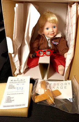 MUÑECA DE PORCELANA VINTAGE NUEVA EN CAJA DANBURY PILOTO COMO NUEVA "TOMMY'" CON JUGUETE AIR PLAIN Foto 1 de 4
