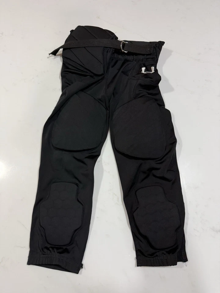 Pantalones de fútbol Under Armour juveniles medianos con almohadillas integradas negros usados en excelente estado Foto 1 de 4