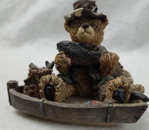 Resin Bear sitting in a boat holding a fish. - Picture 1 of 7