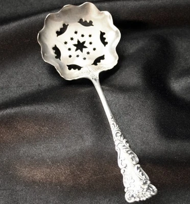 Cuchara para servir pequeña perforada de ley con patrón desconocido Foto 1 de 4
