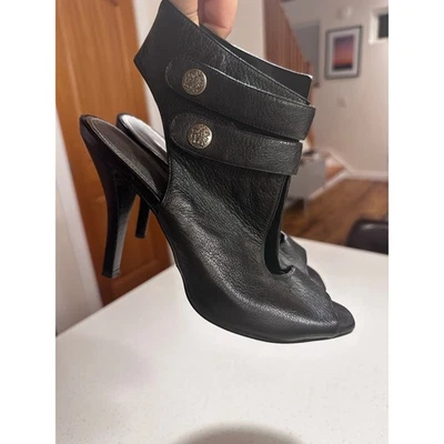 Botas al tobillo Fergie de cuero negras con punta abierta para mujer 8 broches de presión Foto 1 de 4