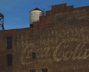 Foto von Altbau mit Werbung und Wasserturm. - Bild 1 von 1