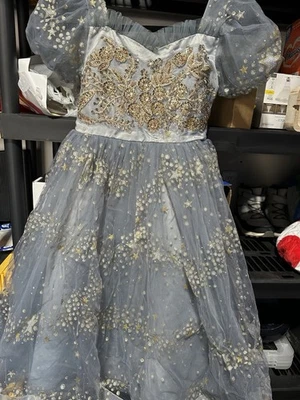 Vestido niña flor tul gris claro con lentejuelas doradas y adornos estrella. Foto 1 de 4