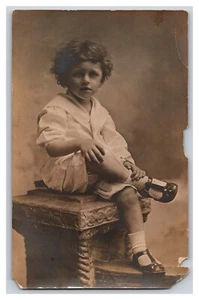 Vintage Anfang 1900 RPPC Kind sitzend gekreuzte Beine Portrait - Bild 1 von 2
