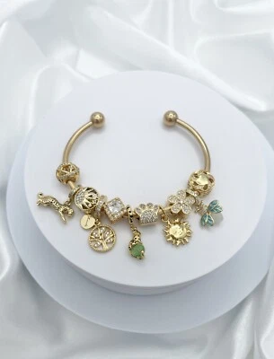 Brazalete abierto Linx oro amarillo con dijes temáticos verdes y dorados Foto 1 de 4