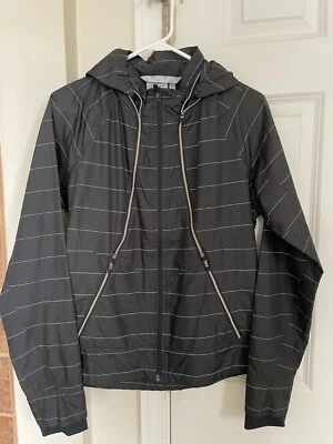 Chaqueta cortavientos para mujer Athleta Run On negra reflectante rayas plateadas mediana Foto 1 de 4