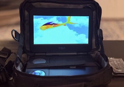 Reproductor de DVD portátil RCA con cargadores, control remoto, estuche de viaje y DVD Pixar REEF Foto 1 de 4