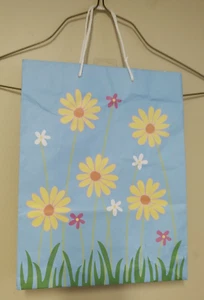 GESCHENKTASCHE MIT GÄNSEBLÜMCHENBLUMEN AUF HELLBLAUEM HINTERGRUND - Bild 1 von 3