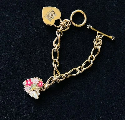 Pulsera medallón vintage Juicy Couture tono dorado con mariposa y floral Foto 1 de 4