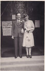 R325462 Man with dark suit and woman with hat and glasses and light colour cloth