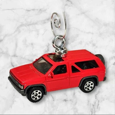 Caja de cerillas 2024 - rojo 1985 Nissan Pathfinder - 54/100 árbol de Navidad OrnamenT 1:64 Foto 1 de 4
