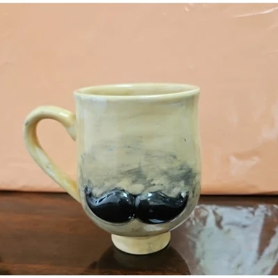 Taza de café lanzada a mano con bigote negro Foto 1 de 4