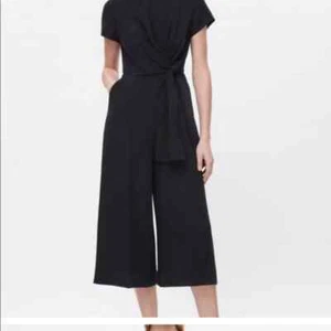 COS Damen Jumpsuit schwarz V-Ausschnitt seitlich zum Binden weites Bein kurzarm Gr. UK 34 - Bild 1 von 11