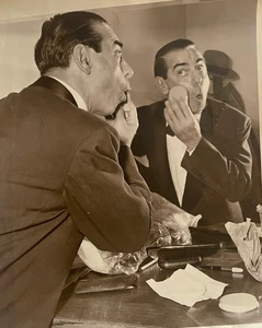 Foto de prensa de entretenimiento de colección de la década de 1950 hombre polvoreándose la cara en el vestidor - Imagen 1 de 4
