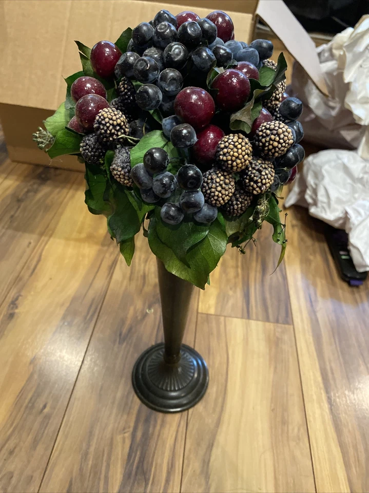 Jarrón con frutos falsos y hojas en él Foto 1 de 1