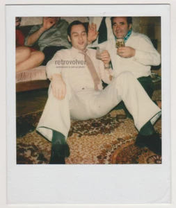 Hübscher junger Mann in weiß schlägt kühne Pose mit gespreizten Beinen Gay Int Polaroid® - Bild 1 von 7