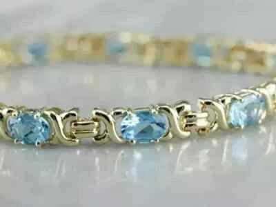 Brazalete de tenis para mujer de aguamarina de corte ovalado de 9 quilates enchapado en oro amarillo de 7,5" Foto 1 de 4