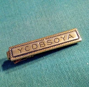 Prendedor de solapa "You Can't Do Business Sitting On Your A_s_s" años 60 con clip de corbata - Imagen 1 de 4