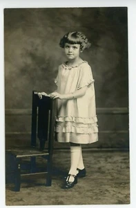 AK Kind Mädchen stehend mit Stuhl Kleid antik unbesendet Echtfoto RPPC - Bild 1 von 2